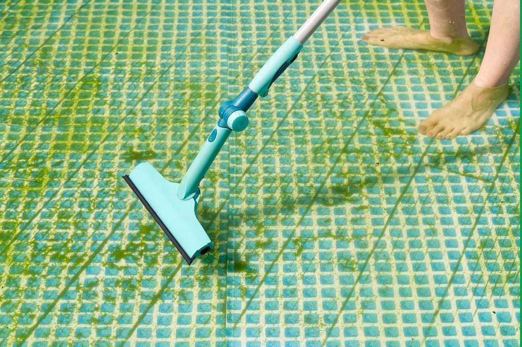 Schoonmaak van wellnesscentra: reinigen van vervuild zwembad met zichtbare algvorming op de bodem