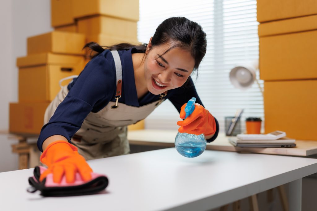 Professionele schoonmaakster maakt een bureau schoon voor/na verhuis