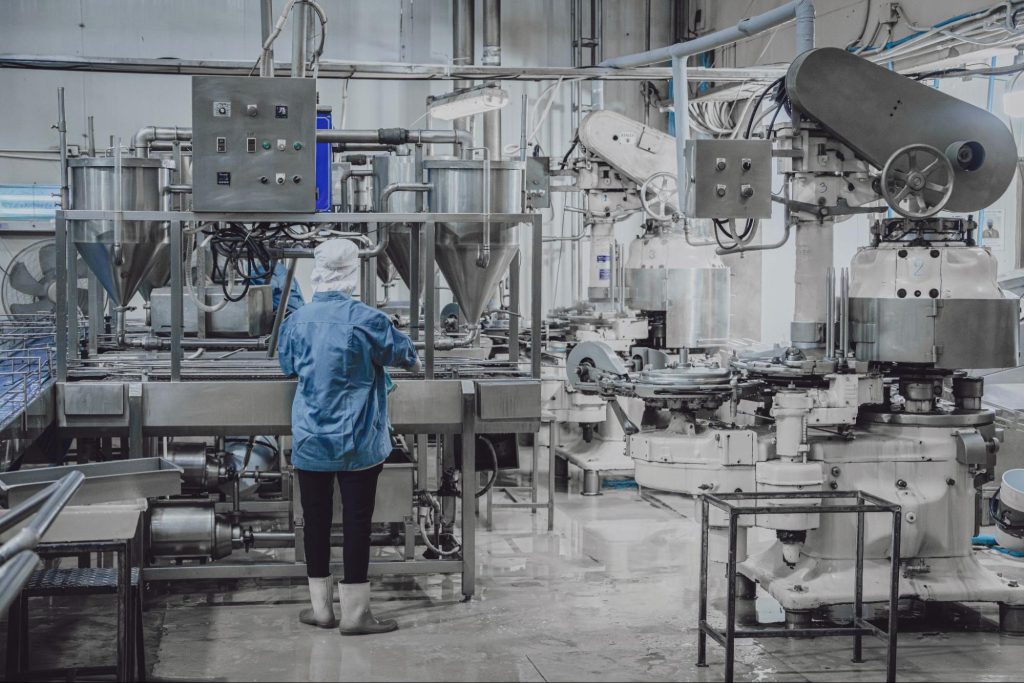 Medewerker in beschermkleding bij industriële reiniging in een slachthuis