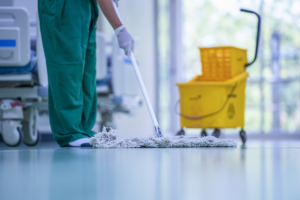 Schoonmaker dweilt professioneel een glanzende vloer in een zorginstelling